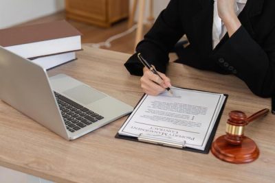 young-female-lawyer-introducing-business-contract-law-in-modern-office-setting-with-legal-documents-and-laptop-photo